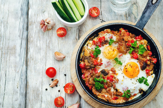 fried eggs with peppers, tomatoes, quinoa and mushrooms