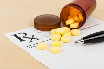 Medicine on blank prescription form with pen focus on pill