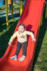 Fototapeta na wymiar child falls from the red slide