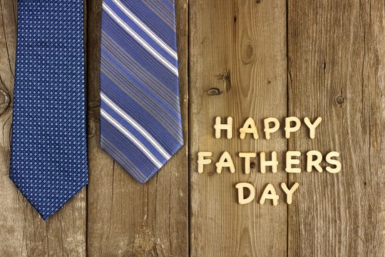 Happy Fathers Day letters on a wood background with blue ties