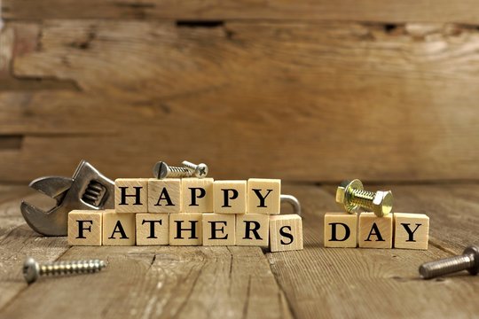 Happy Fathers Day blocks with tools on a rustic wood background