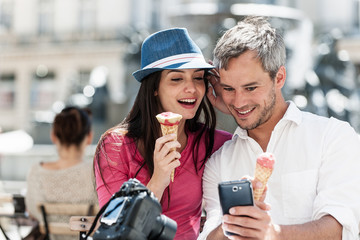 Portrait of a smiling couple eating ice cream in the city.