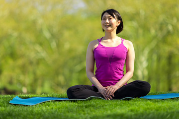 Young Asian woman fitness in a park yoga meditation