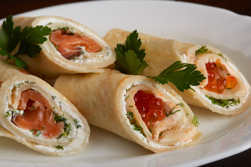 Delicious rolls of pita with salmon and red caviar