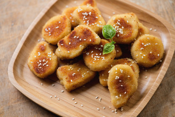 Bamboo tray with sesame chicken nuggets, high angle view