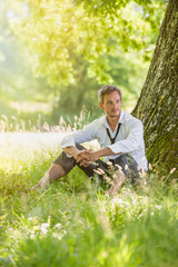 Naklejka na ściany i meble handsome grey hair man taking a break, barefoot in the grass