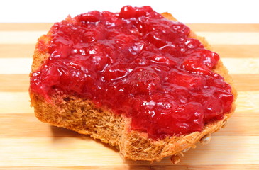 Obraz premium Portion of wheat bread with strawberry jam
