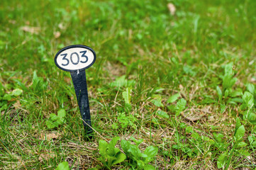 Schild markiert eine Stelle im Gras