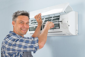 Male Technician Repairing Air Conditioner