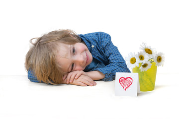 Adorable little boy with daisy bouquet and a red heart card 