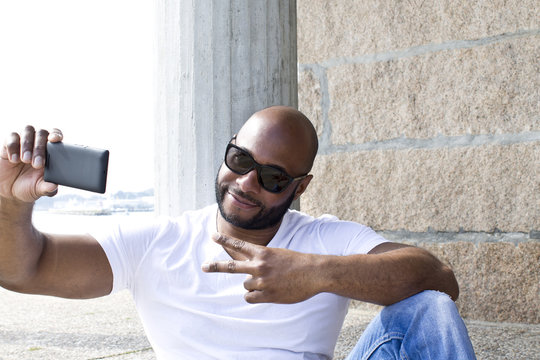black man with ok symbol and mobile phone