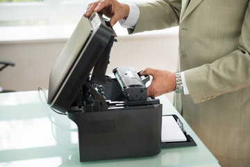 Businessman Fixing Cartridge In Photocopy Machine