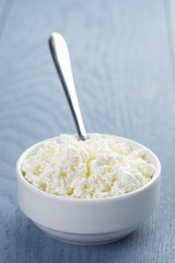 cottage cheese in white bowl on blue wooden table