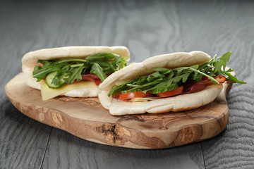 rustic sandwiches with ham arugula and tomatoes in pita bread