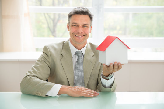 Happy Businessman Holding House Model