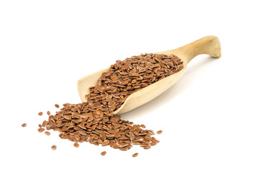 Wooden spoon floating over with linseed on white background