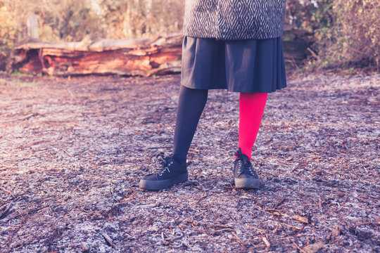 Woman wearing odd leggings on frosty ground