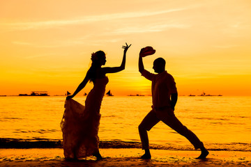 bride and groom having fun on a tropical beach with the sunset 