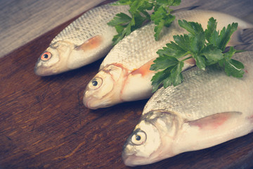 Three fish on a wooden board
