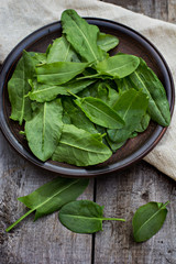 sorrel leaves on a plate, the plate is on the old boards