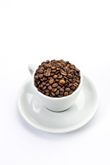 White coffee cup with saucer, and coffee-beans isolated on white