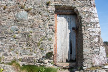 Fototapeta na wymiar Hintergrund – irische Natursteinmauer mit Holztür