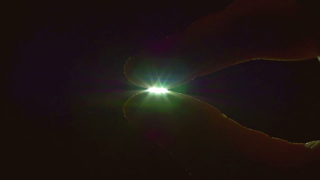 The hand take and hold the star (sun) by bright rays background. Slow motion capture. Shot with Red Cinema Camera