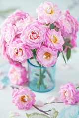 Obraz na płótnie Canvas Beautiful fresh pink roses on a table. light background.