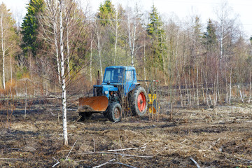 Fototapeta premium tractor work the land among the trees