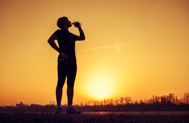 Runner drinks water after training