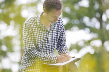 Environmentalist Writing On Notepad In Park