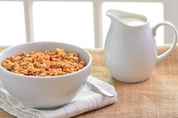 Breakfast Muesli cereal clusters with a jug of fresh milk.