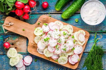 salad of fresh organic radish and cucumber on cutting board 