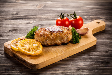 Fried chops and vegetables on cutting board 