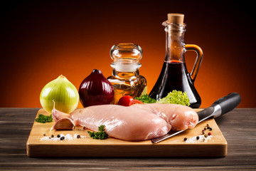Raw chicken breasts on cutting board 