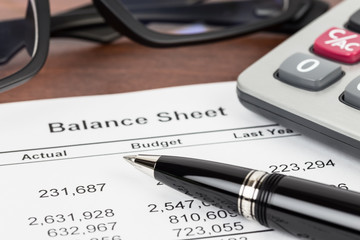 Balance sheet financial report focus at pen; document is mock-up
