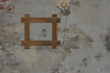 roher Bilderrahmen aus Holz auf roher Wand aus Stein