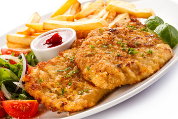 Fried pork chops, French fries and vegetables