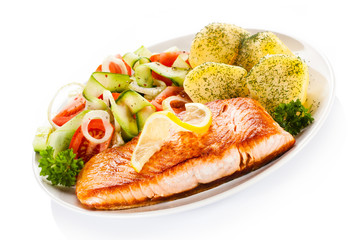 Fried salmon and vegetables on white background