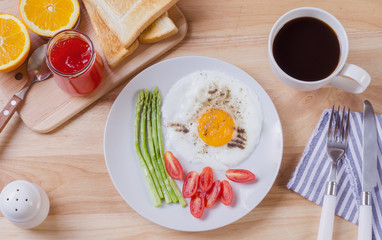 Healthy breakfast with fried egg, toasts and strawberry jam on w