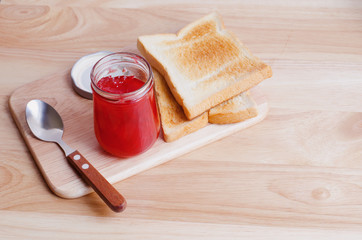 Breakfast with toasts and strawberry jam on wooden table