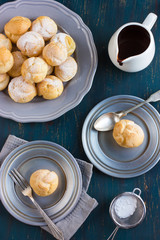 profiteroles with cream and chocolate sauce on dark blue backgro