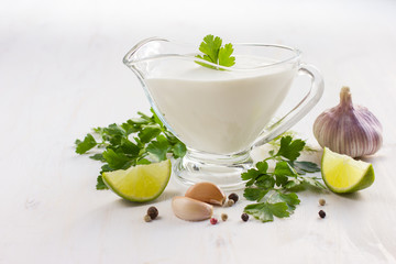 creamy sauce on glass sauceboat and ingredients