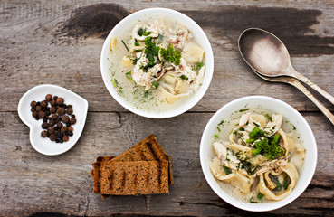 A bowl of soup with noodles and chicken 