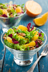 Healthy salad mix with orange and walnuts in glass