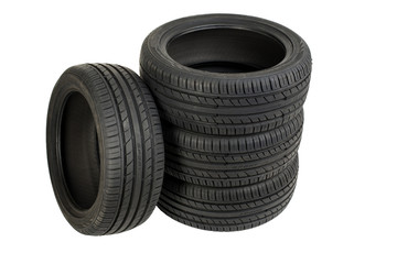 Stack of four wheel new black tyres isolated on white