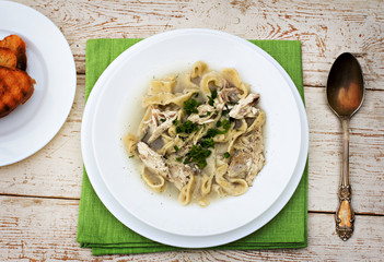 A bowl of soup with noodles and chicken 