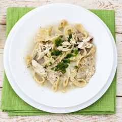 A bowl of soup with noodles and chicken 