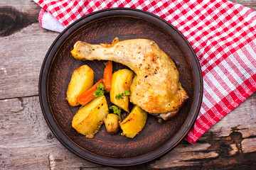Baked chicken pieces with potatoes, herbs and garlic 