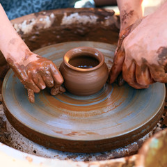 Hands working on pottery wheel